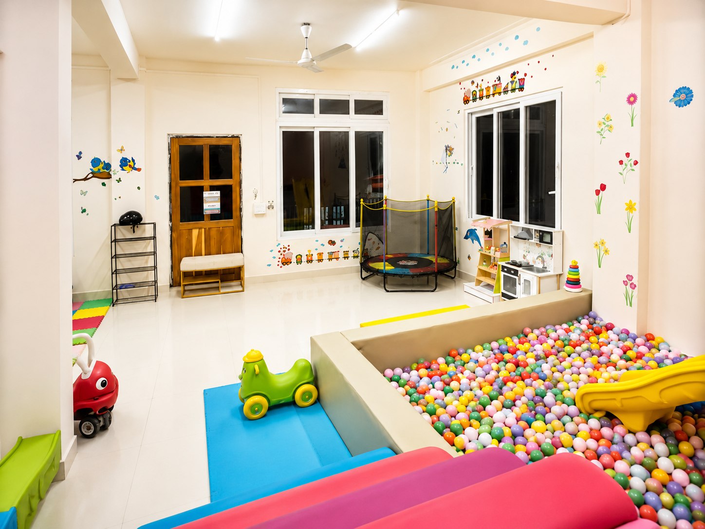 The Play Hive indoor play area with a ball pit, slide, trampoline, toys, and ride-on cars